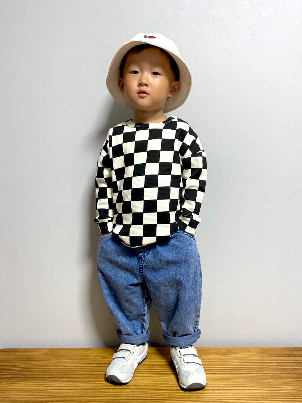 ブラック系のTシャツ/カットソー、ブルー系のデニムパンツ、グレー系のスニーカーを着用したキッズの秋コーディネートの3枚目の写真