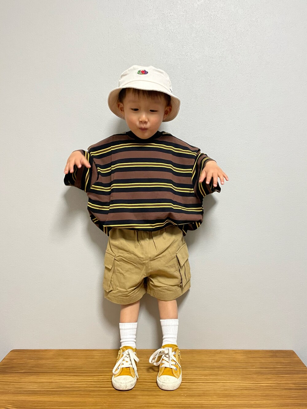 ブラウン系のTシャツ/カットソー、ベージュ系のその他パンツ、イエロー系のスニーカーを着用したキッズの春コーディネートの2枚目の写真