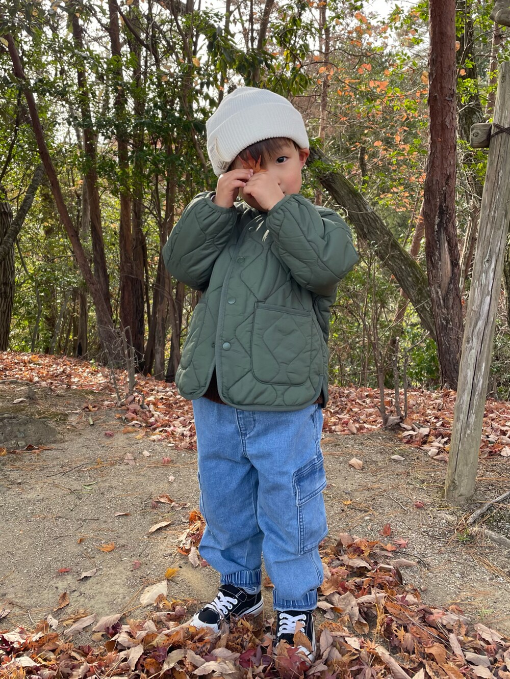 ブラウン系のニット/セーター、グリーン系のノーカラージャケット、ブルー系のカーゴパンツを着用したキッズの冬コーディネートの3枚目の写真