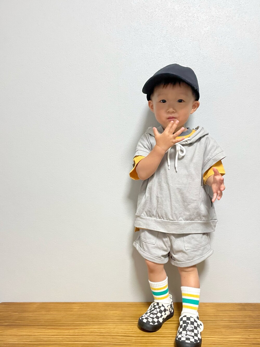 グレー系のスウェット、ブラック系のスリッポン、オレンジ系のTシャツ/カットソーを着用したキッズの春コーディネートの3枚目の写真