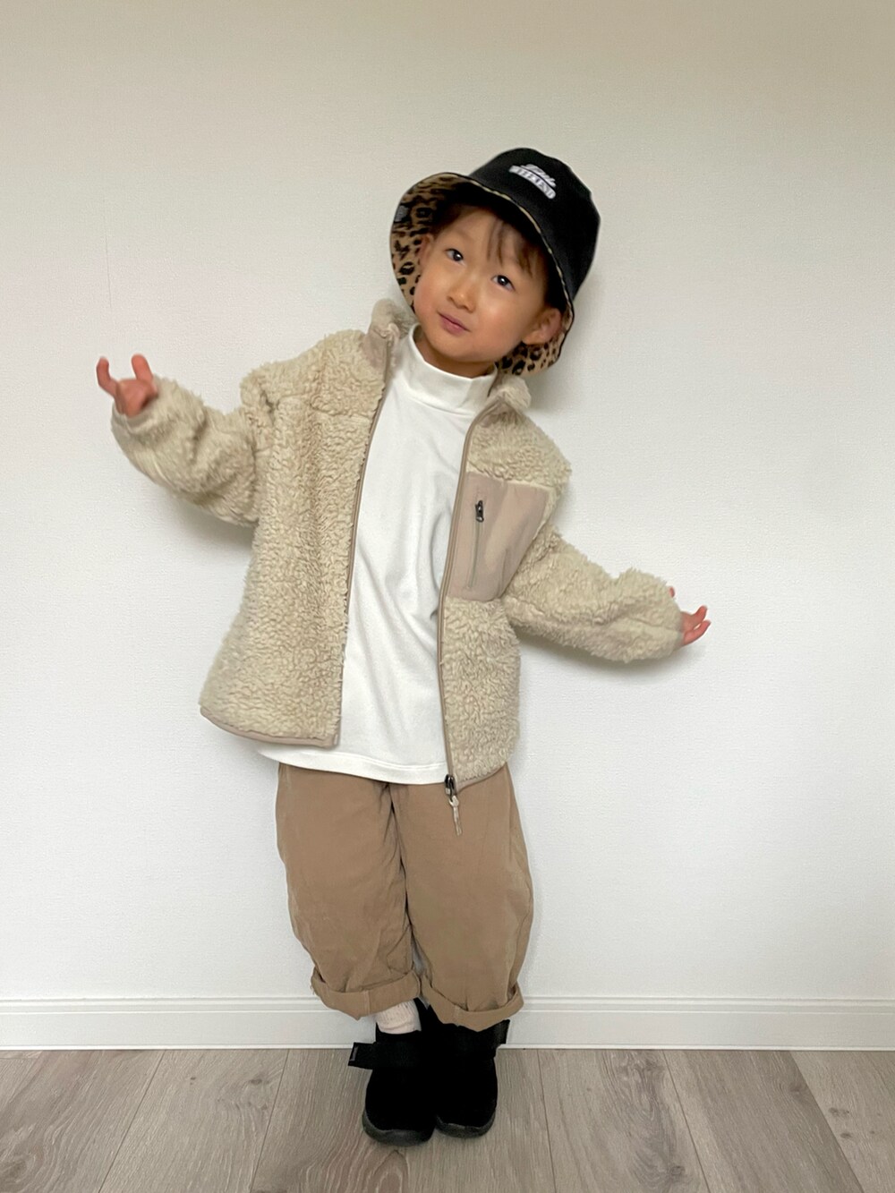 ベージュ系のその他アウター、ホワイト系のTシャツ/カットソー、ベージュ系のパンツを着用したキッズの冬コーディネートの2枚目の写真