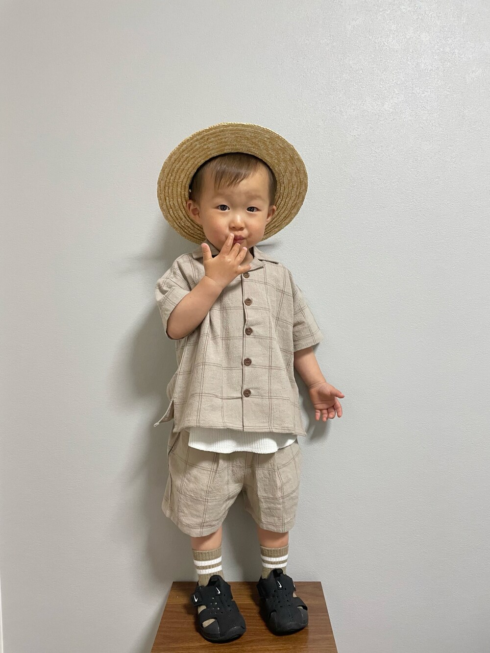 ブラック系のサンダル、ベージュ系のセットアップ、ホワイト系のタンクトップを着用したキッズの春コーディネートの3枚目の写真