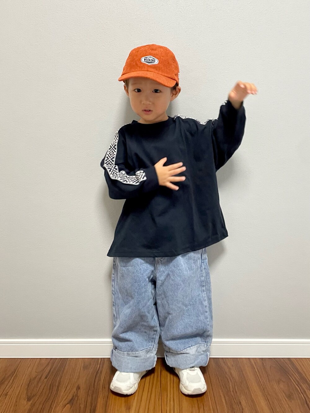 ブラック系のTシャツ/カットソー、ブルー系のデニムパンツ、ホワイト系のスニーカーを着用したキッズの秋コーディネートの4枚目の写真