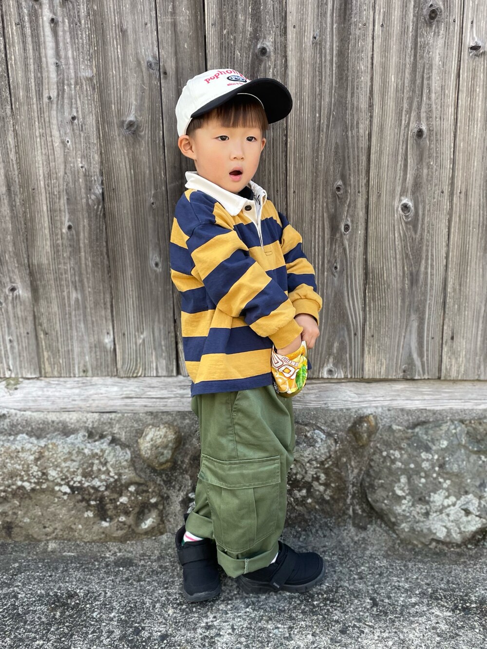 イエロー系のTシャツ/カットソー、グリーン系のカーゴパンツ、ブラック系のスニーカーを着用したキッズの秋コーディネートの2枚目の写真
