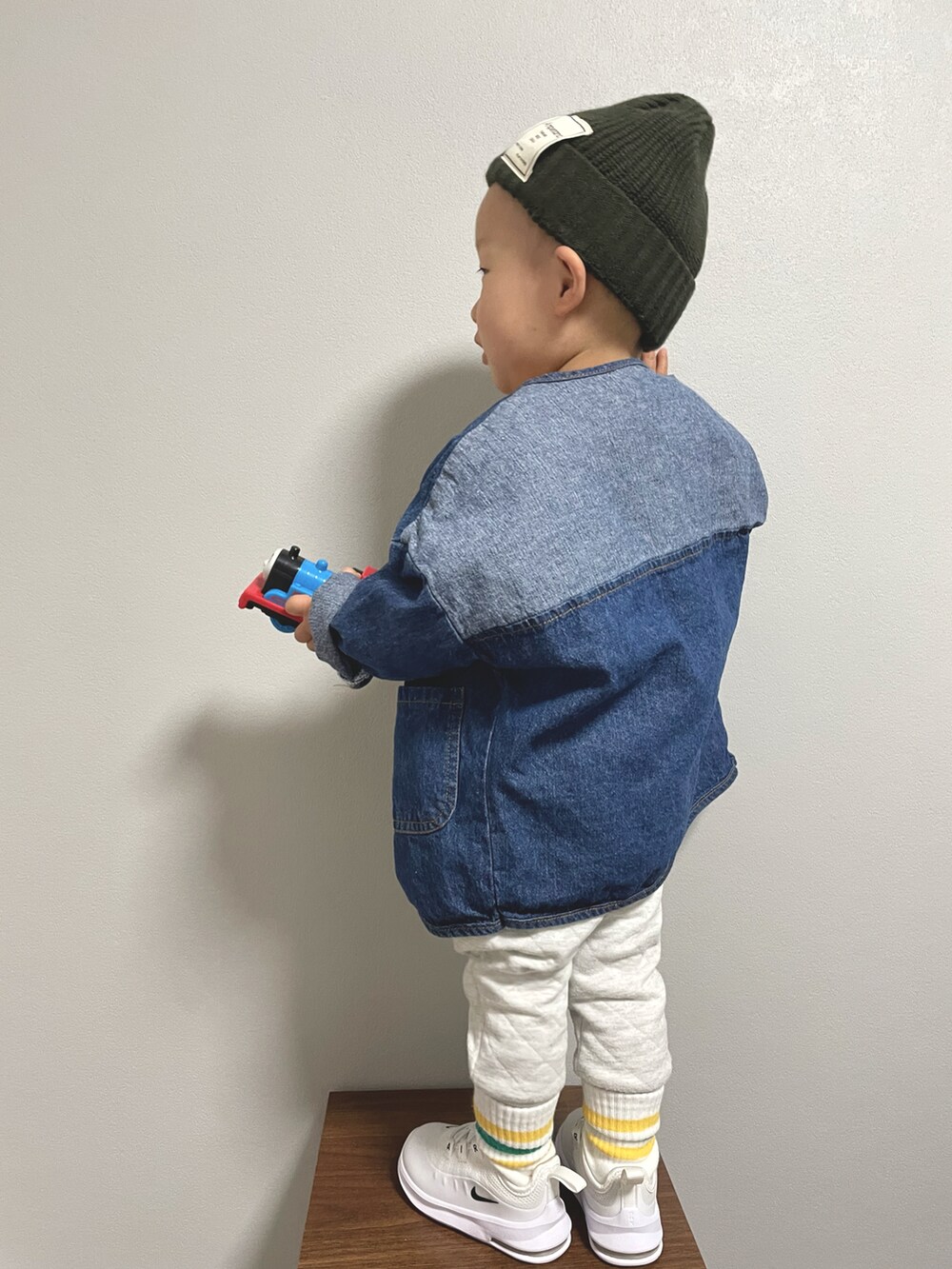 イエロー系のスウェット、ブルー系のデニムジャケット、ホワイト系のその他パンツを着用したキッズの冬コーディネートの4枚目の写真