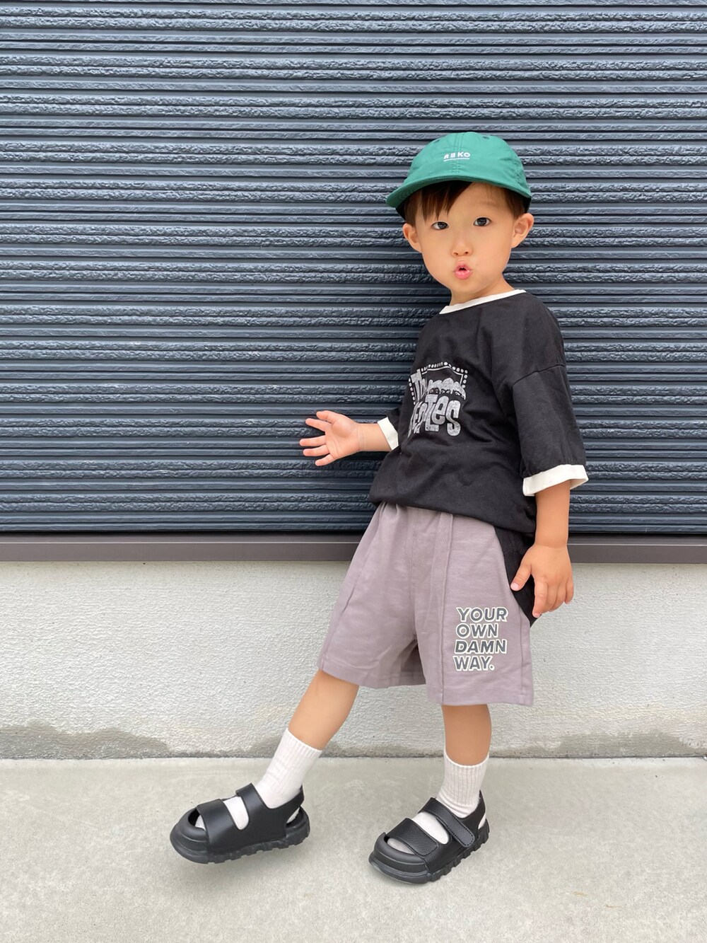 ブラック系のTシャツ/カットソー、グレー系のスウェットパンツ、ブラック系のサンダルを着用したキッズの夏コーディネートの3枚目の写真