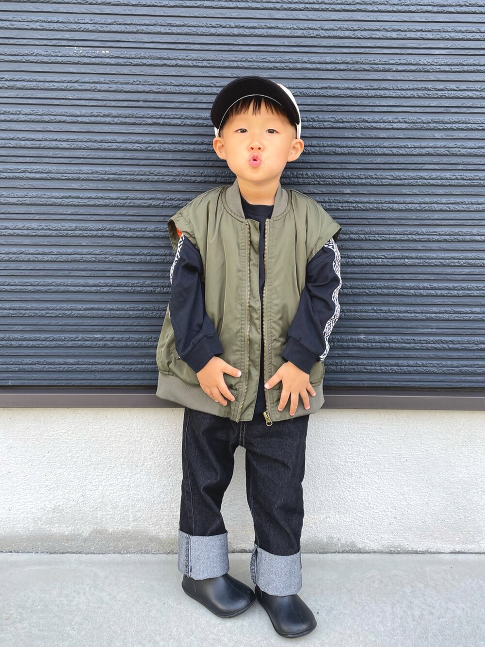 グリーン系のMA-1、ブラック系のTシャツ/カットソー、ブルー系のデニムパンツを着用したキッズの秋コーディネートの2枚目の写真