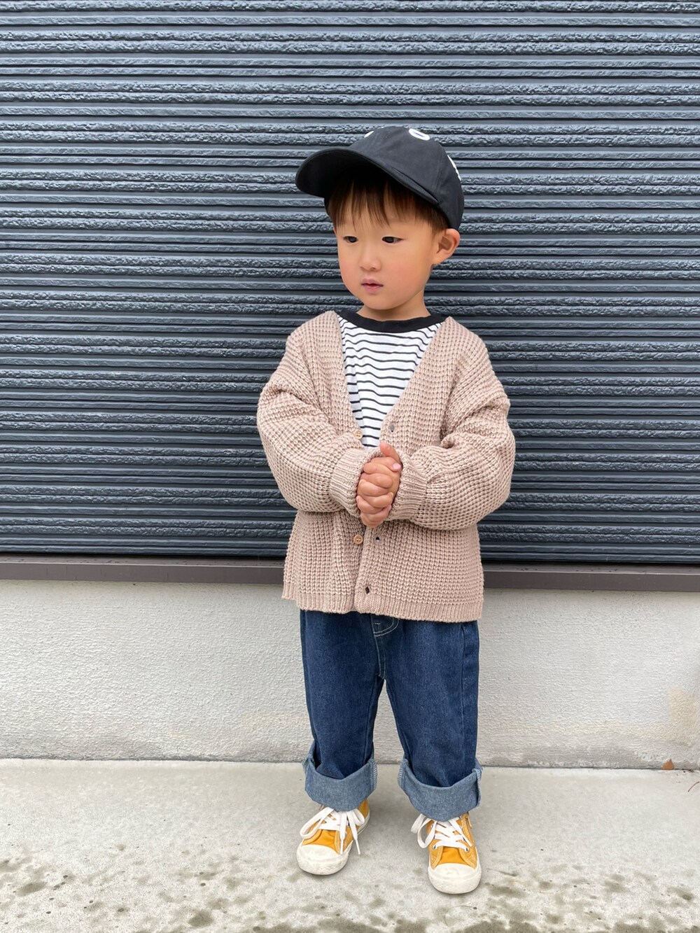 ブラック系のTシャツ/カットソー、ブルー系のデニムパンツ、イエロー系のスニーカーを着用したキッズの春コーディネートの3枚目の写真