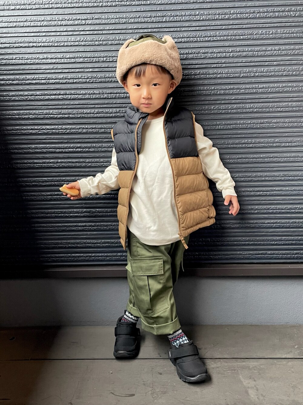 ブラウン系のダウンジャケット/コート、ブラック系のスニーカー、ブルー系のソックス/靴下を着用したキッズの秋コーディネートの2枚目の写真