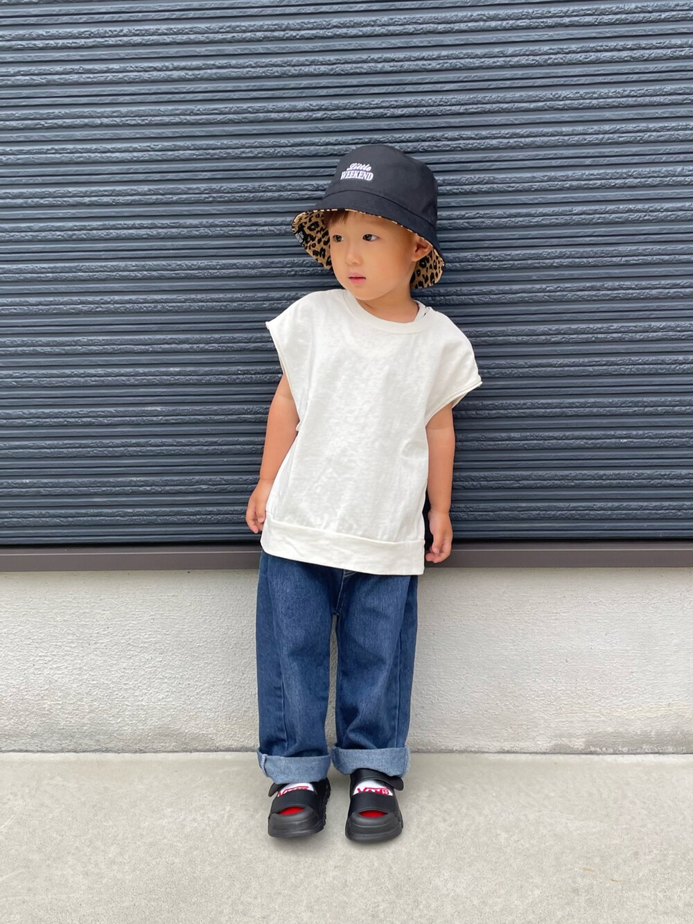 ホワイト系のTシャツ/カットソー、ブルー系のデニムパンツ、ブラック系のサンダルを着用したキッズの春コーディネートの2枚目の写真