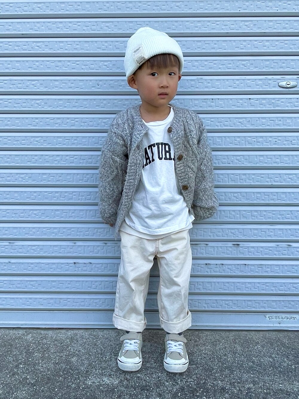 ホワイト系のTシャツ/カットソー、グレー系のカーディガン/ボレロ、ホワイト系のデニムパンツを着用したキッズの秋コーディネートの3枚目の写真