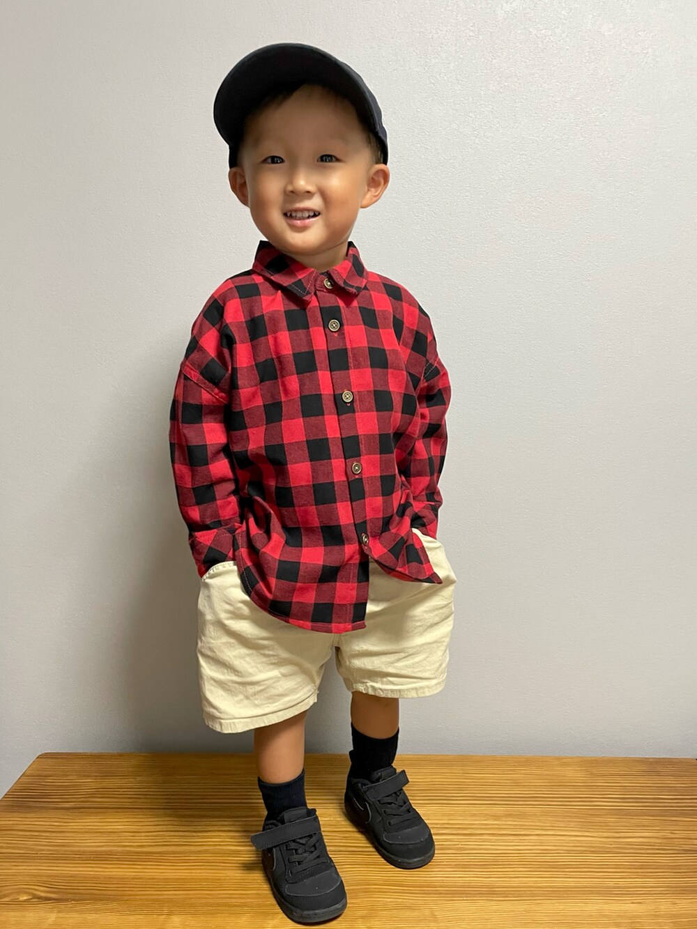 レッド系のシャツ/ブラウス、ベージュ系のその他パンツ、ブラック系のスニーカーを着用したキッズの秋コーディネートの4枚目の写真