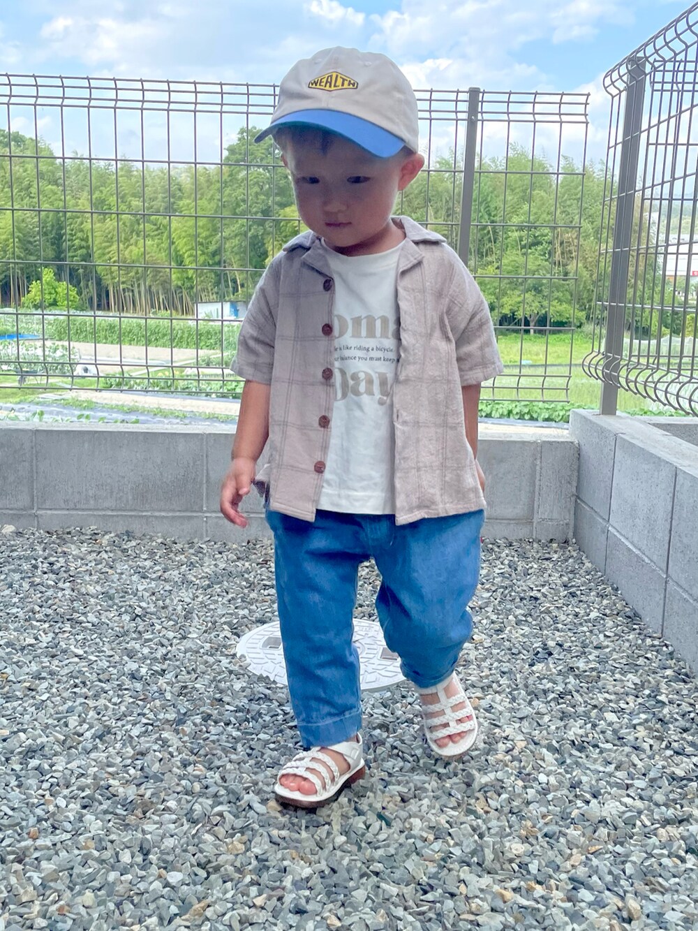 ベージュ系のセットアップ、ベージュ系のTシャツ/カットソー、ブルー系のデニムパンツを着用したキッズの夏コーディネートの5枚目の写真