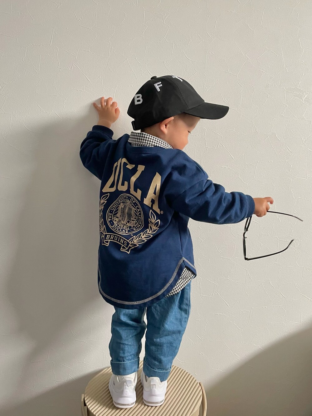 グリーン系のスウェット、ブラック系のシャツ/ブラウス、ブルー系のデニムパンツを着用したキッズの春コーディネートの4枚目の写真