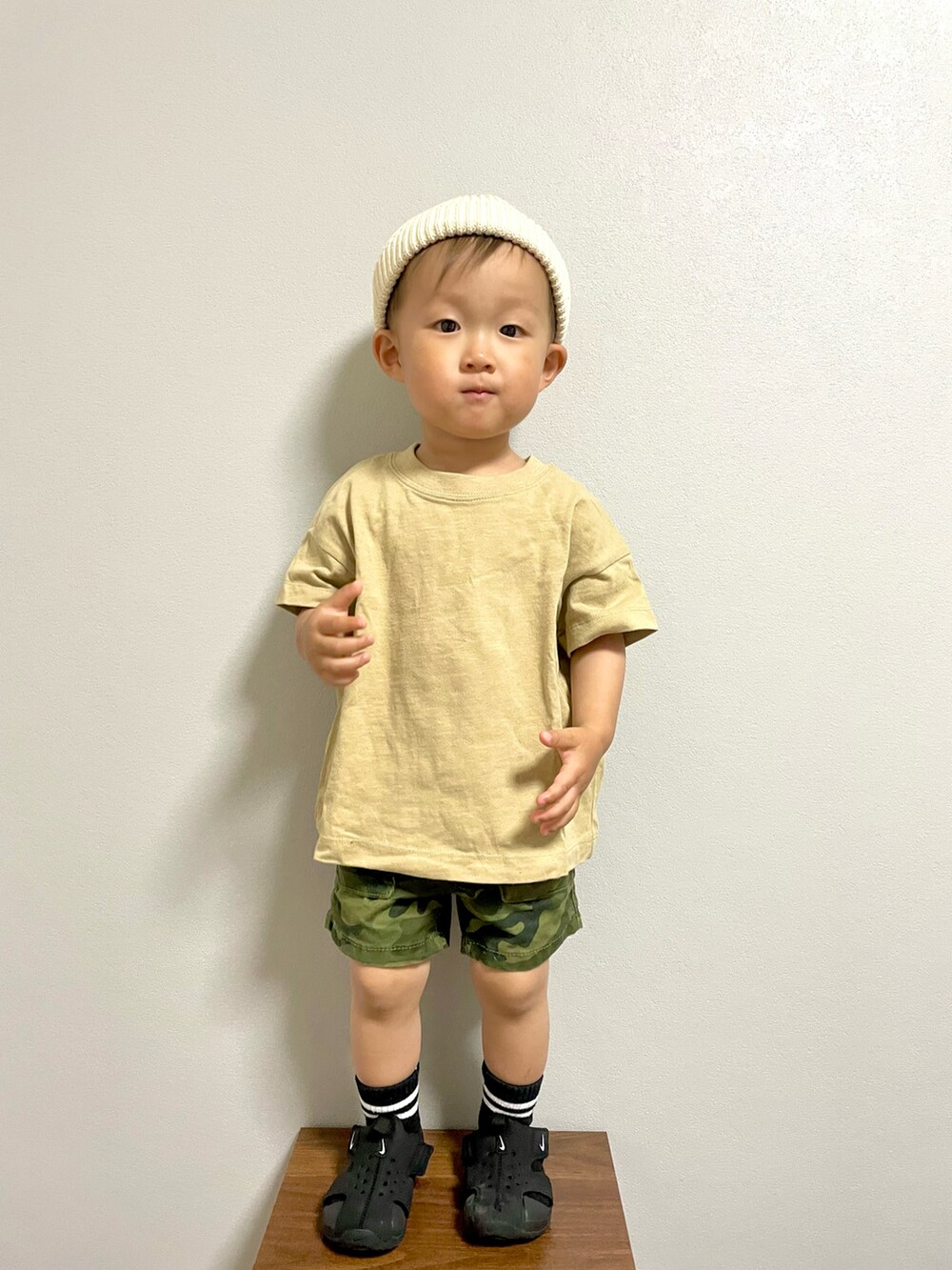 グリーン系のカーゴパンツ、ブラック系のサンダル、ホワイト系のニットキャップ/ビーニーを着用したキッズの春コーディネートの3枚目の写真