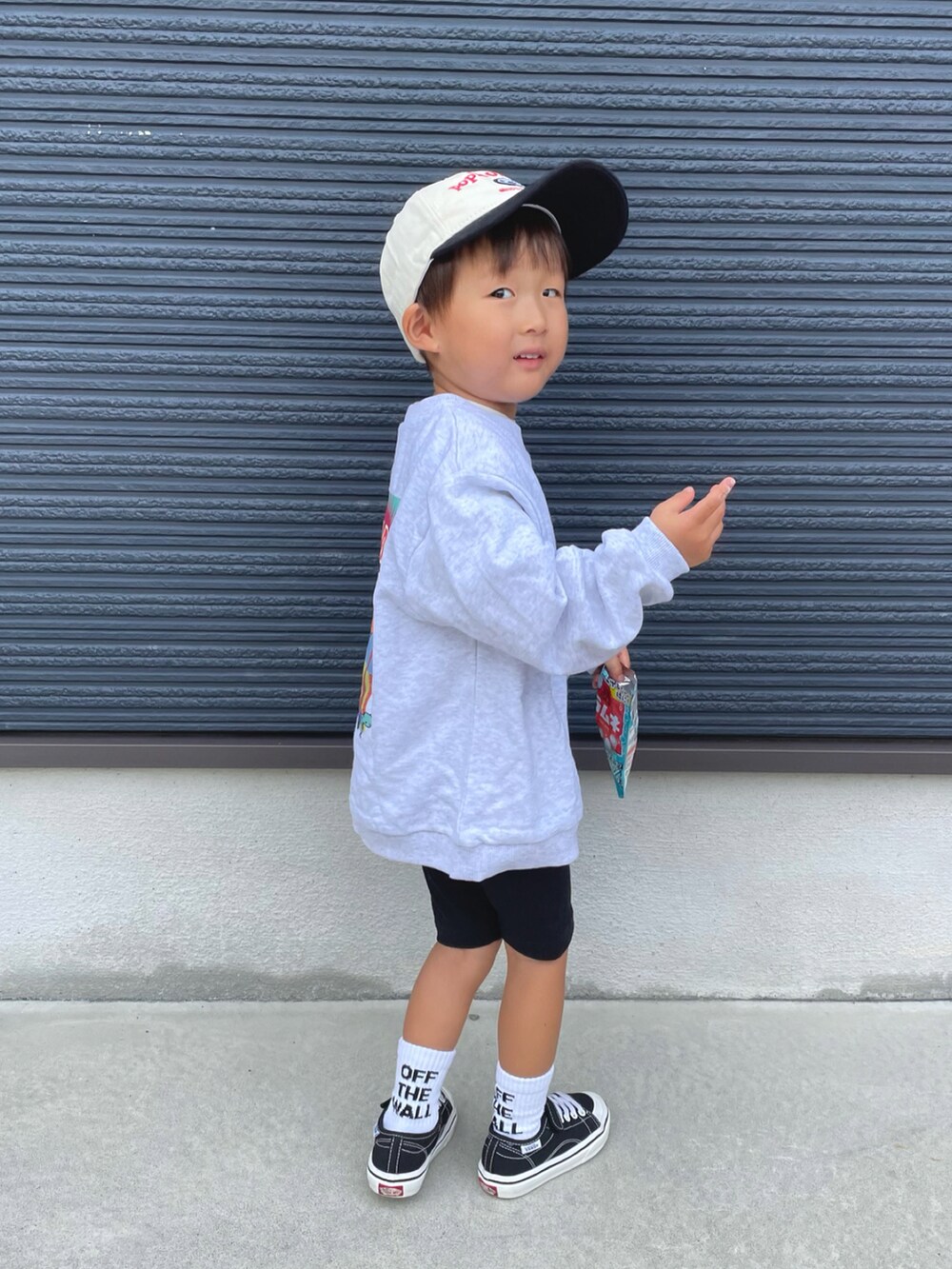 グレー系のスウェット、ブラック系のスニーカー、ブラック系のキャップを着用したキッズの秋コーディネートの3枚目の写真