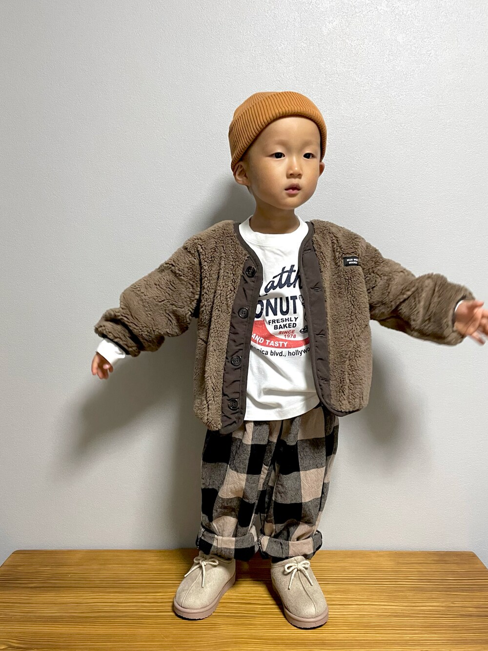 ホワイト系のTシャツ/カットソー、ブラウン系のブルゾン、ベージュ系のその他パンツを着用したキッズの秋コーディネートの2枚目の写真