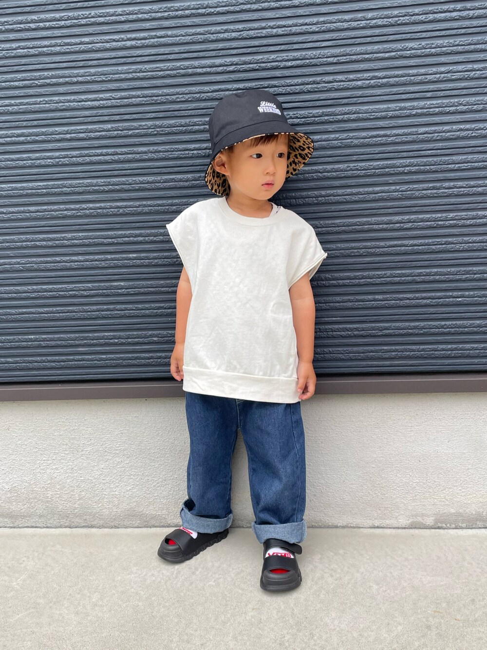 ホワイト系のTシャツ/カットソー、ブルー系のデニムパンツ、ブラック系のサンダルを着用したキッズの春コーディネートの4枚目の写真