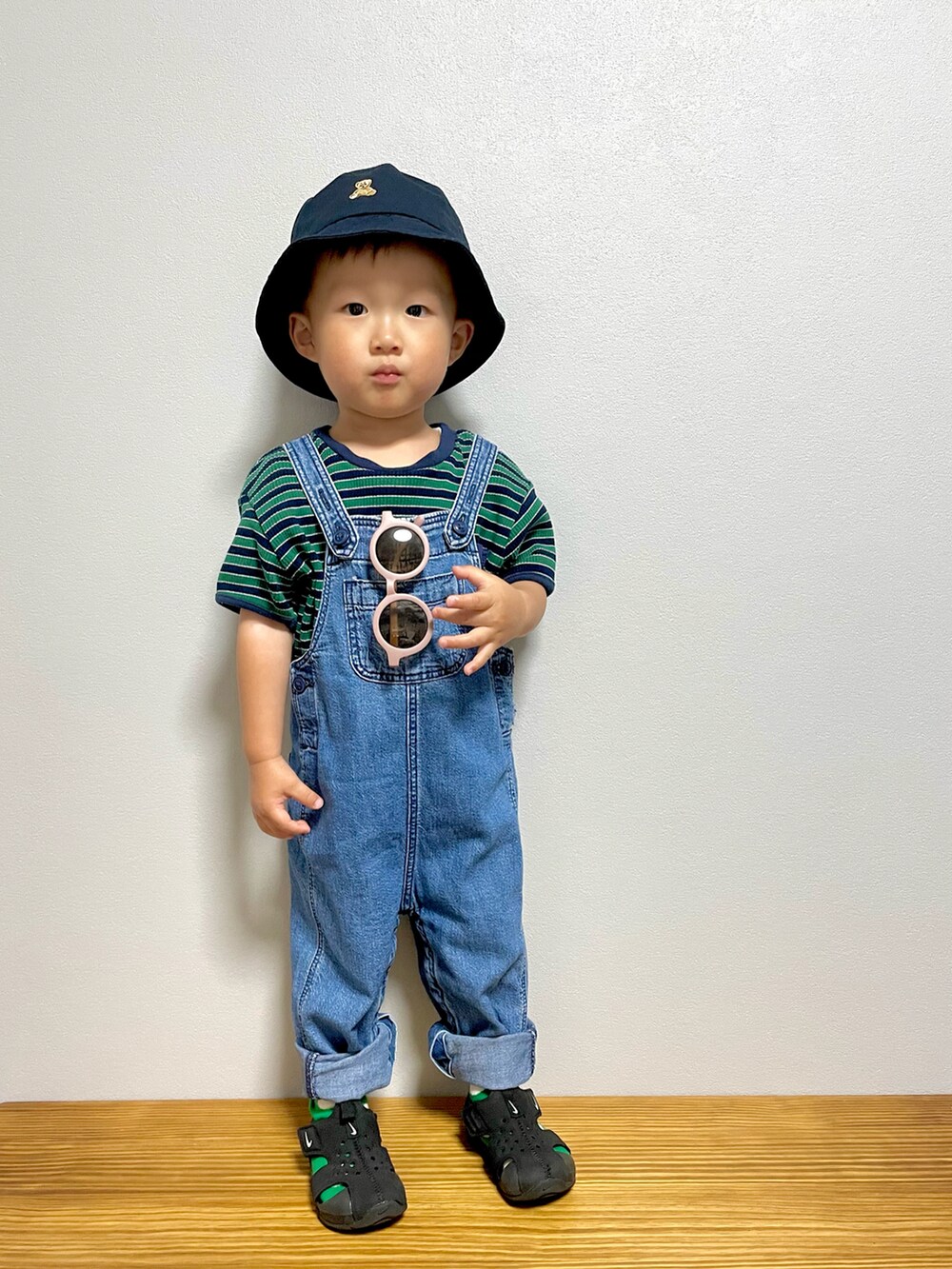 グリーン系のTシャツ/カットソー、ブルー系のサロペット/オーバーオール、ブラック系のサンダルを着用したキッズの夏コーディネートの3枚目の写真