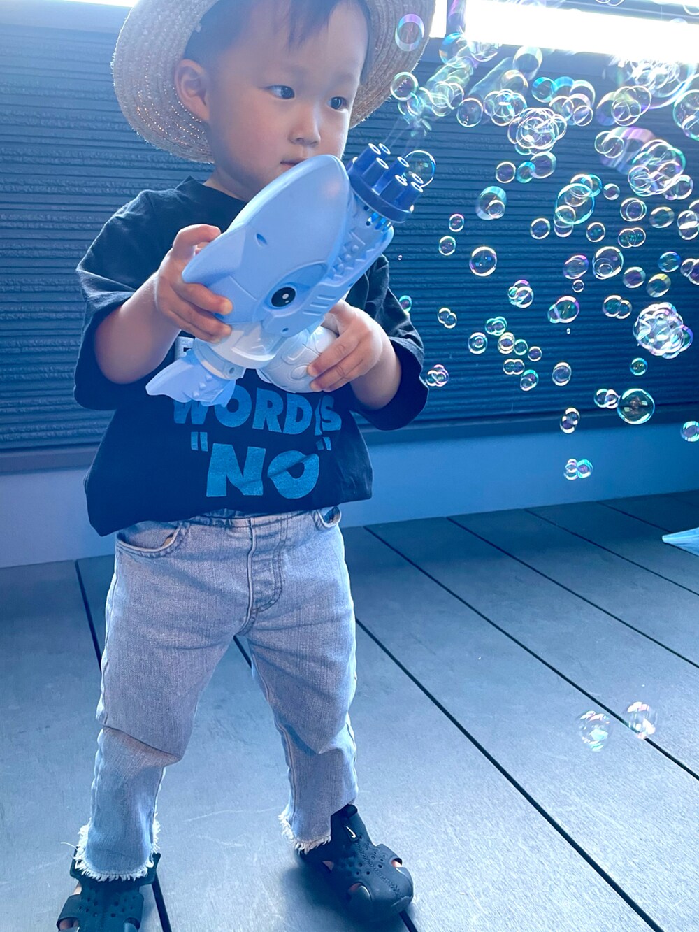 ブラック系のTシャツ/カットソー、ブルー系のデニムパンツ、ブラック系のサンダルを着用したキッズの夏コーディネートの5枚目の写真