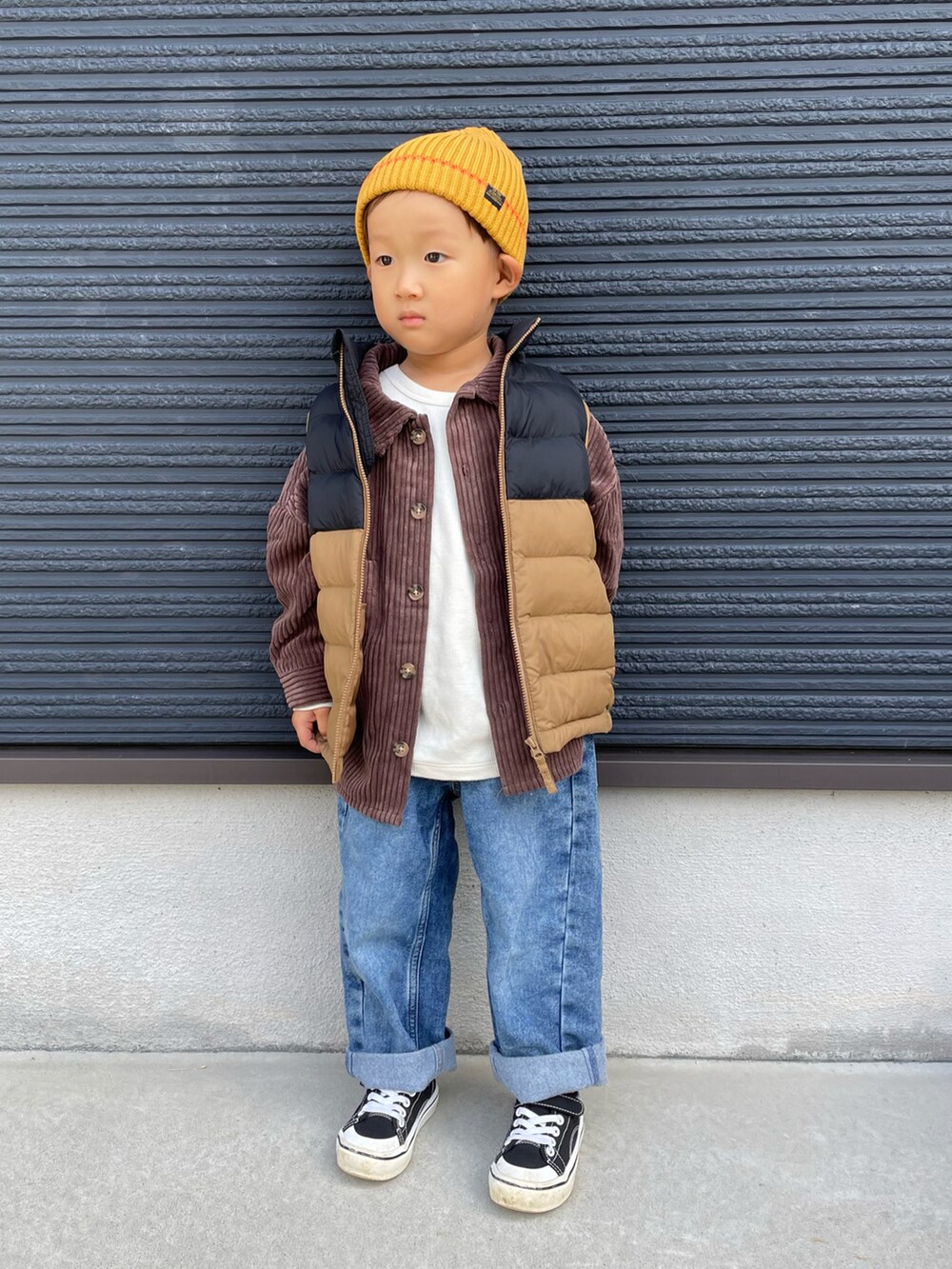 ブラウン系のシャツ/ブラウス、ブラウン系のダウンジャケット/コート、ブルー系のデニムパンツを着用したキッズの秋コーディネートの2枚目の写真