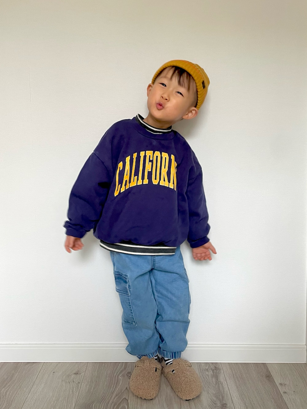 ブラック系のTシャツ/カットソー、ブルー系のスウェット、ブルー系のカーゴパンツを着用したキッズの冬コーディネートの2枚目の写真