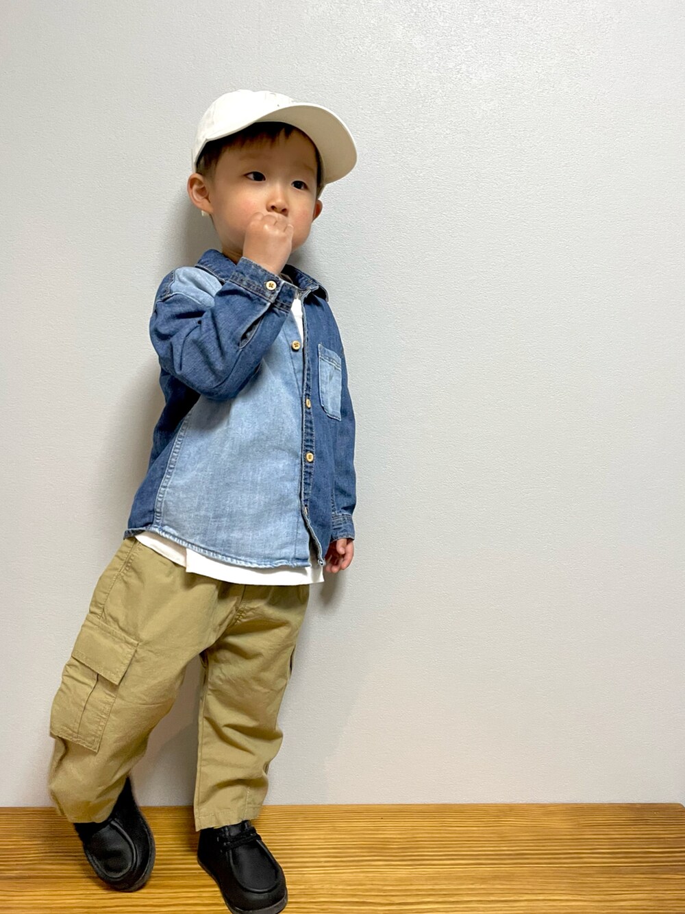 ホワイト系のTシャツ/カットソー、ベージュ系のカーゴパンツ、ブラック系のブーツを着用したキッズの春コーディネートの2枚目の写真