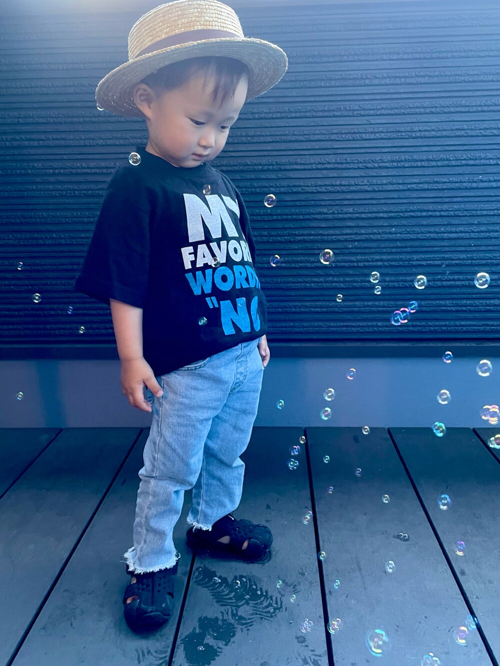 ブラック系のTシャツ/カットソー、ブルー系のデニムパンツ、ブラック系のサンダルを着用したキッズの夏コーディネートの3枚目の写真