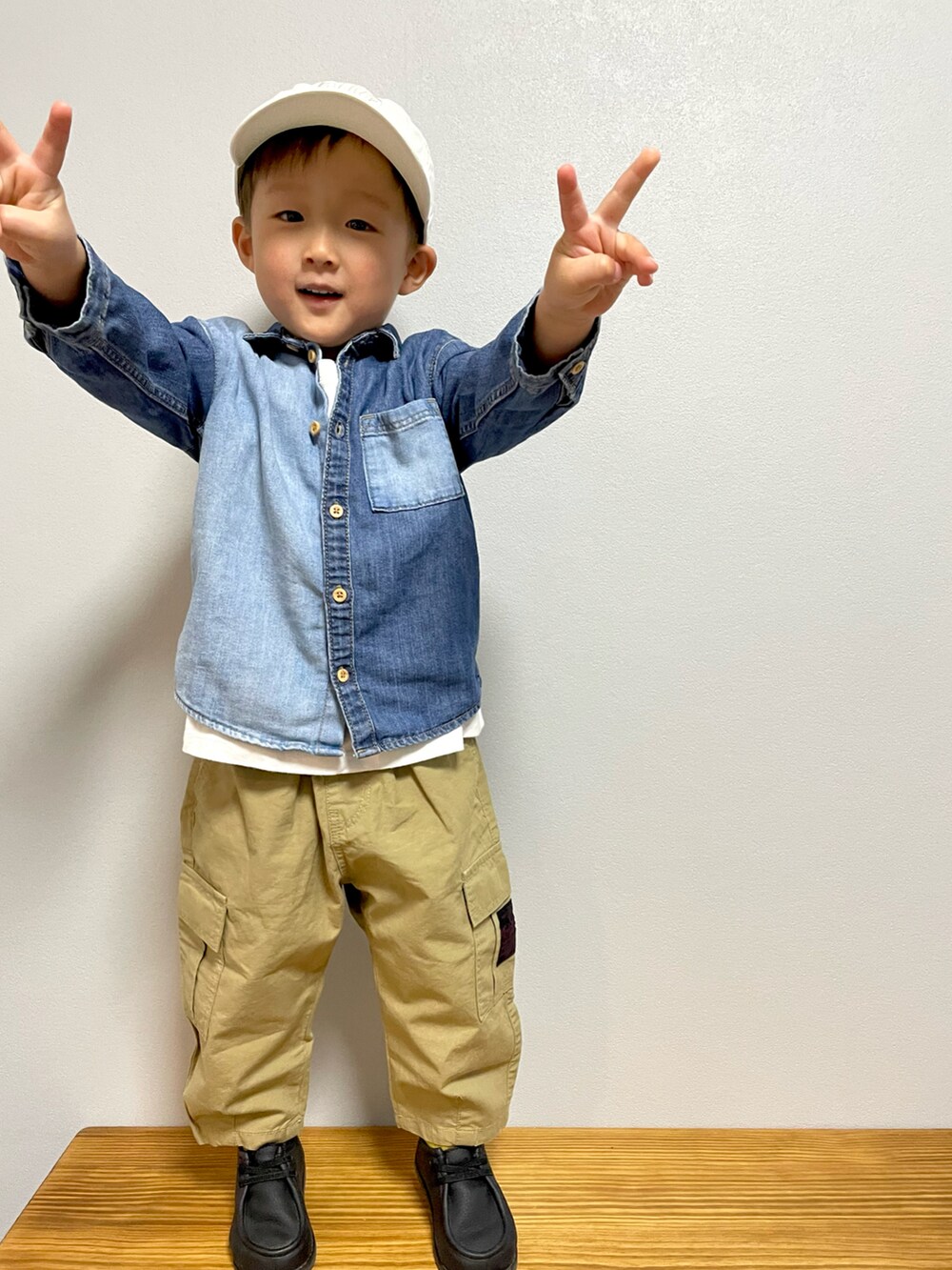 ホワイト系のTシャツ/カットソー、ベージュ系のカーゴパンツ、ブラック系のブーツを着用したキッズの春コーディネートの5枚目の写真