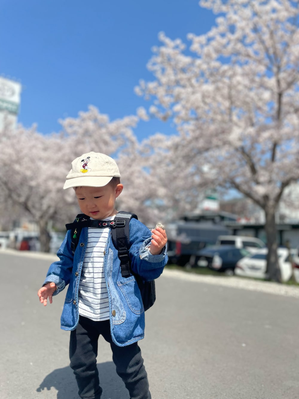 ブルー系のデニムジャケット、ブルー系のシューズ、ブラック系のバックパック/リュックを着用したキッズの春コーディネートの2枚目の写真