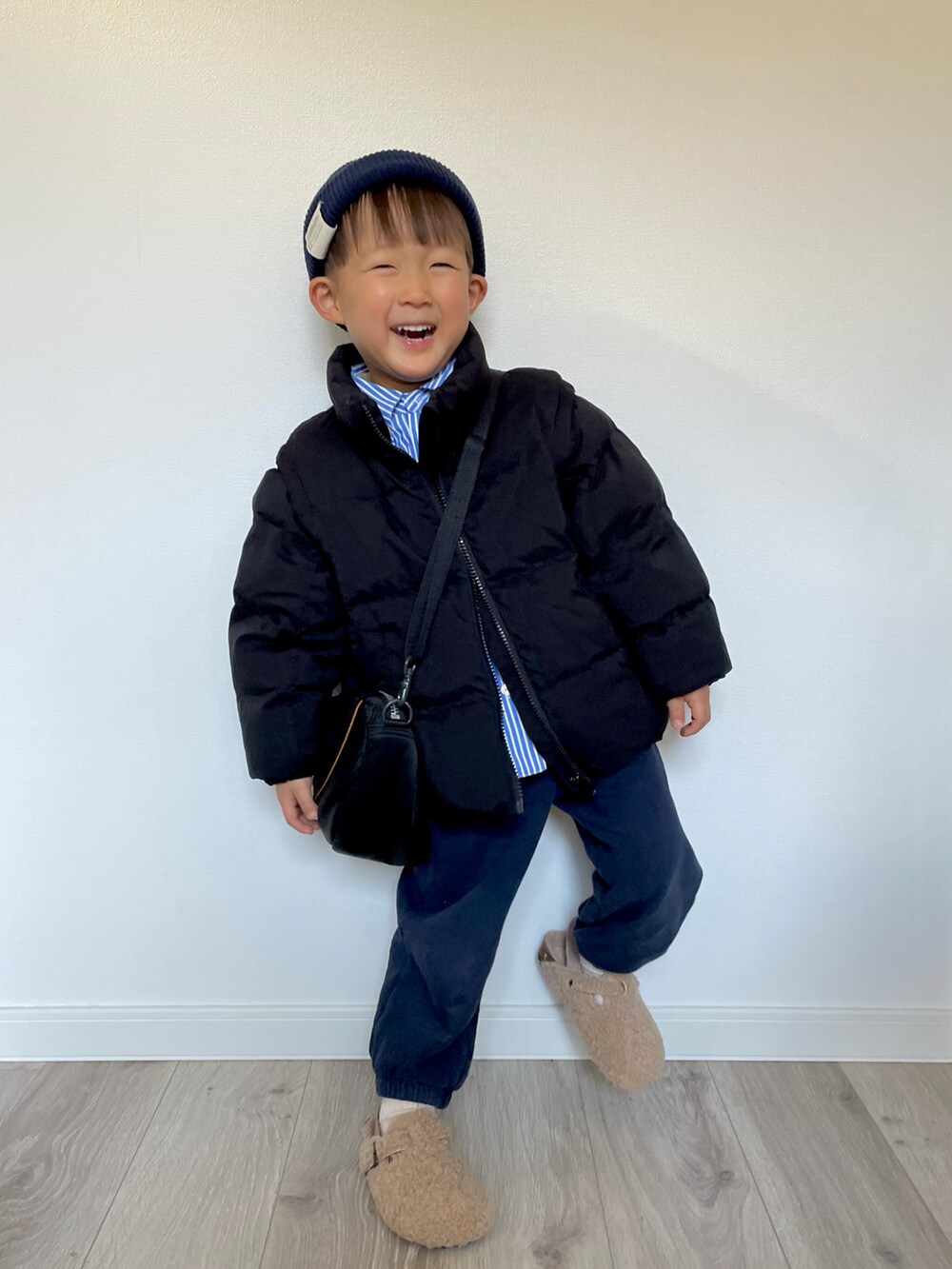 ブラック系のブルゾン、ブラック系のショルダーバッグ、ブルー系のシャツ/ブラウスを着用したキッズの冬コーディネートの2枚目の写真