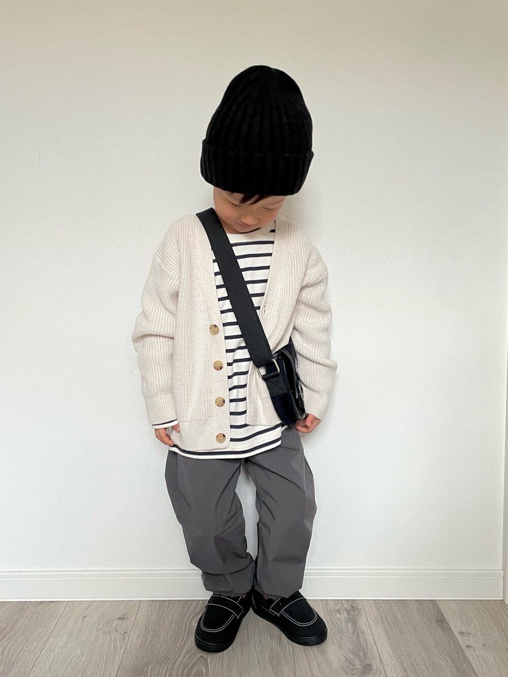 ホワイト系のTシャツ/カットソー、ホワイト系のカーディガン/ボレロ、ブラック系のショルダーバッグを着用したキッズの冬コーディネートの4枚目の写真