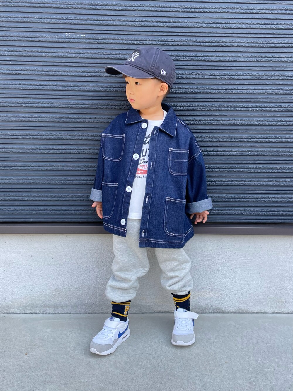 ホワイト系のTシャツ/カットソー、ブルー系のデニムジャケット、グレー系のスウェットパンツを着用したキッズの秋コーディネートの2枚目の写真