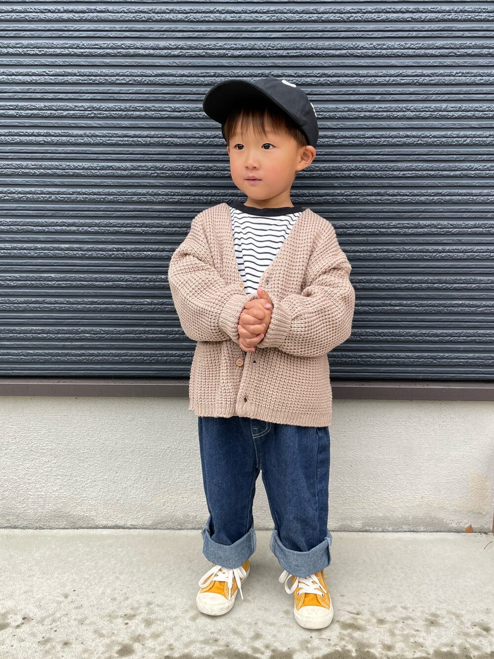 ブラック系のTシャツ/カットソー、ブルー系のデニムパンツ、イエロー系のスニーカーを着用したキッズの春コーディネートの2枚目の写真