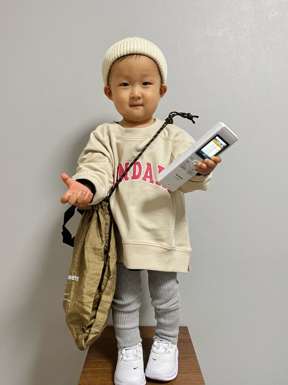 ベージュ系のスウェット、ブラウン系のエコバッグ/サブバッグ、ブラック系のTシャツ/カットソーを着用したキッズの冬コーディネートの3枚目の写真