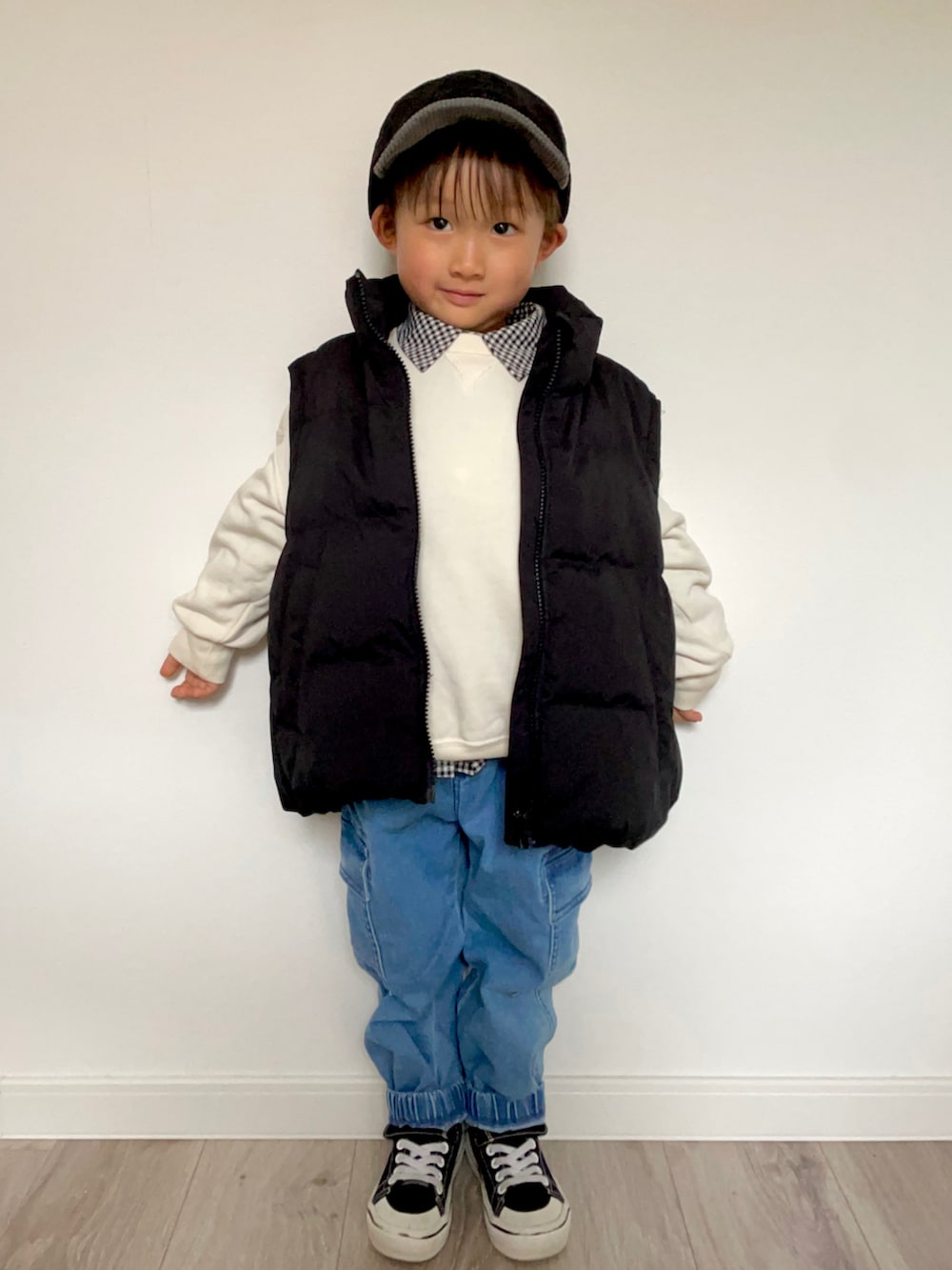 ブラック系のブルゾン、ブルー系のカーゴパンツ、ブラック系のスニーカーを着用したキッズの冬コーディネートの2枚目の写真