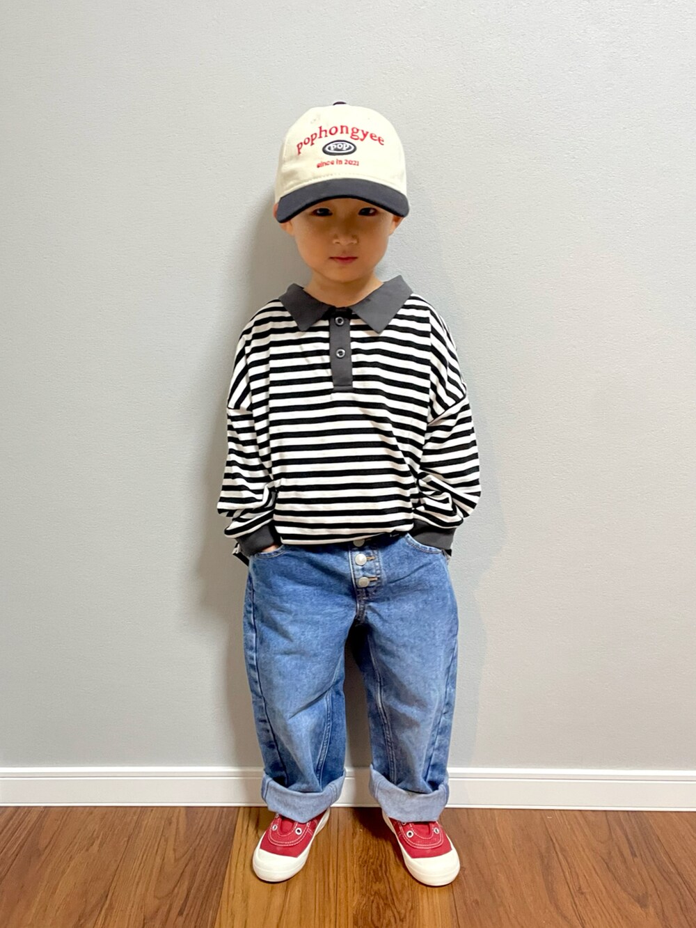 ブラック系のTシャツ/カットソー、ブラック系のショルダーバッグ、ブルー系のデニムパンツを着用したキッズの秋コーディネートの5枚目の写真