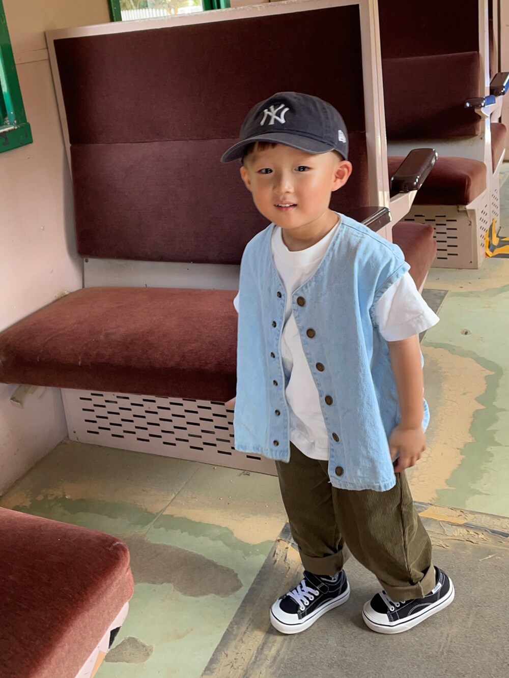 ブルー系のベスト、ブラウン系のその他パンツ、ブラック系のスニーカーを着用したキッズの秋コーディネートの2枚目の写真