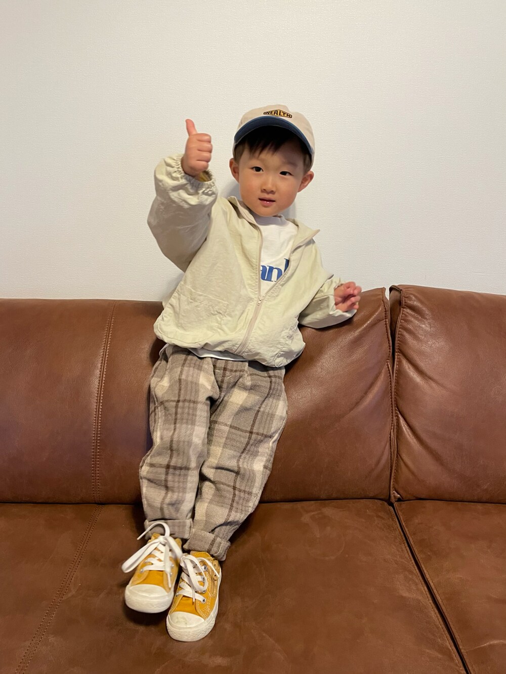 ベージュ系のナイロンジャケット、ホワイト系のTシャツ/カットソー、イエロー系のスニーカーを着用したキッズの春コーディネートの2枚目の写真