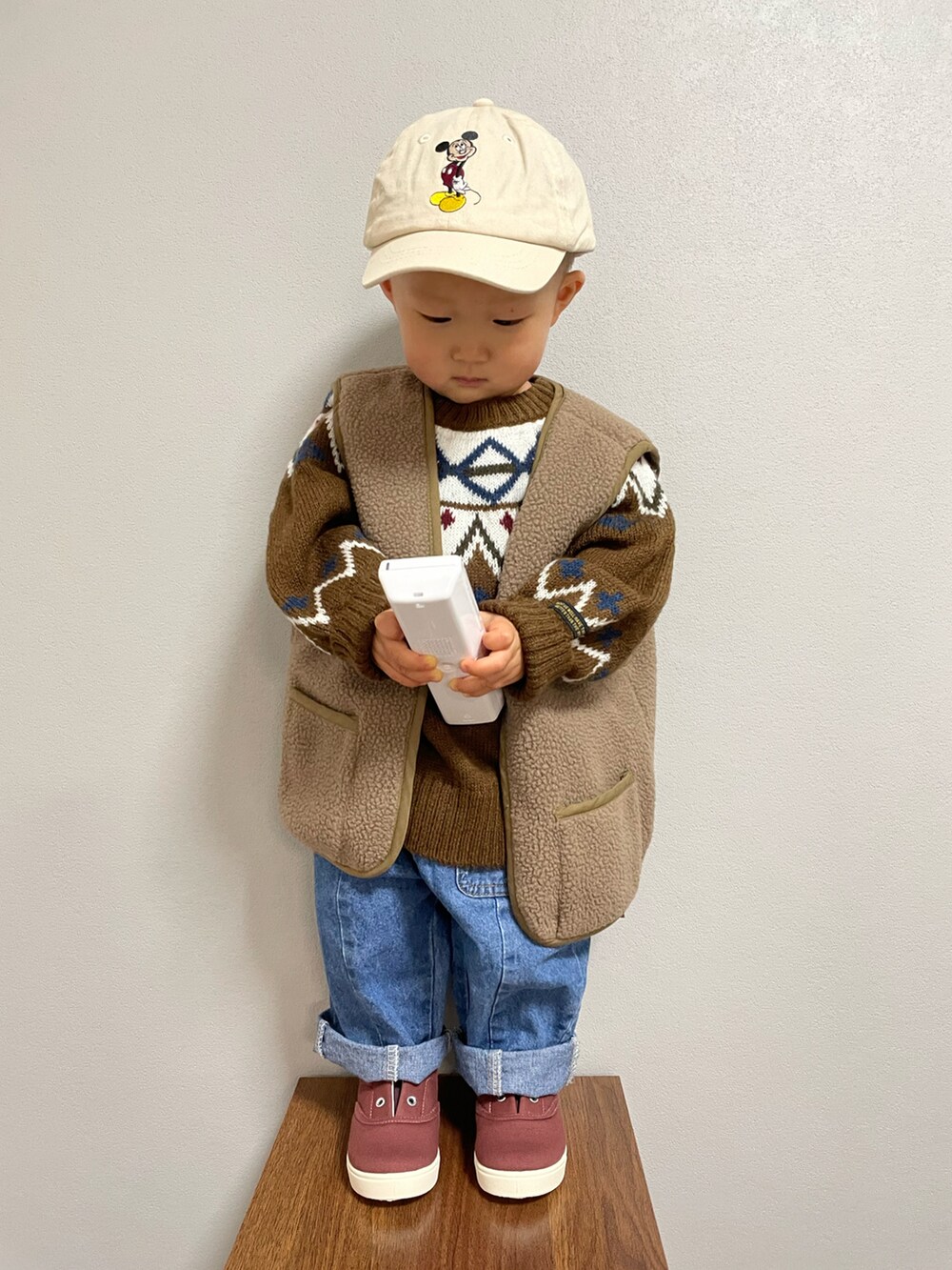 グリーン系のその他アウター、ブラウン系のニット/セーター、ブルー系のデニムパンツを着用したキッズの冬コーディネートの3枚目の写真