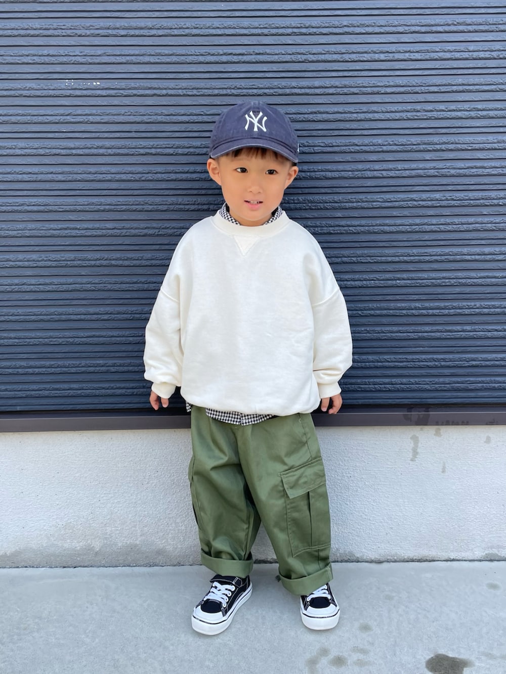 ホワイト系のスウェット、ブラック系のシャツ/ブラウス、グリーン系のカーゴパンツを着用したキッズの秋コーディネートの2枚目の写真