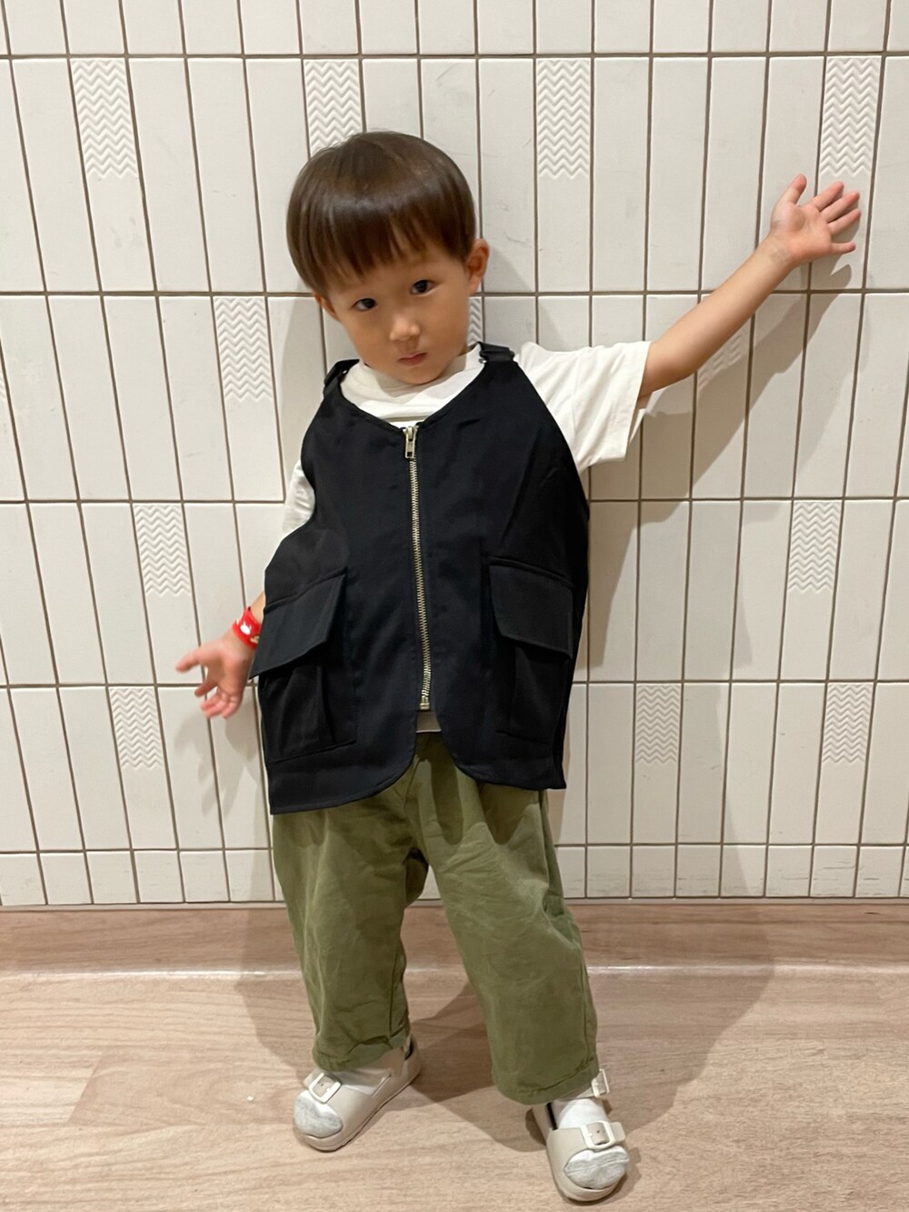 ホワイト系のTシャツ/カットソー、グリーン系のその他パンツ、ベージュ系のサンダルを着用したキッズの秋コーディネートの3枚目の写真