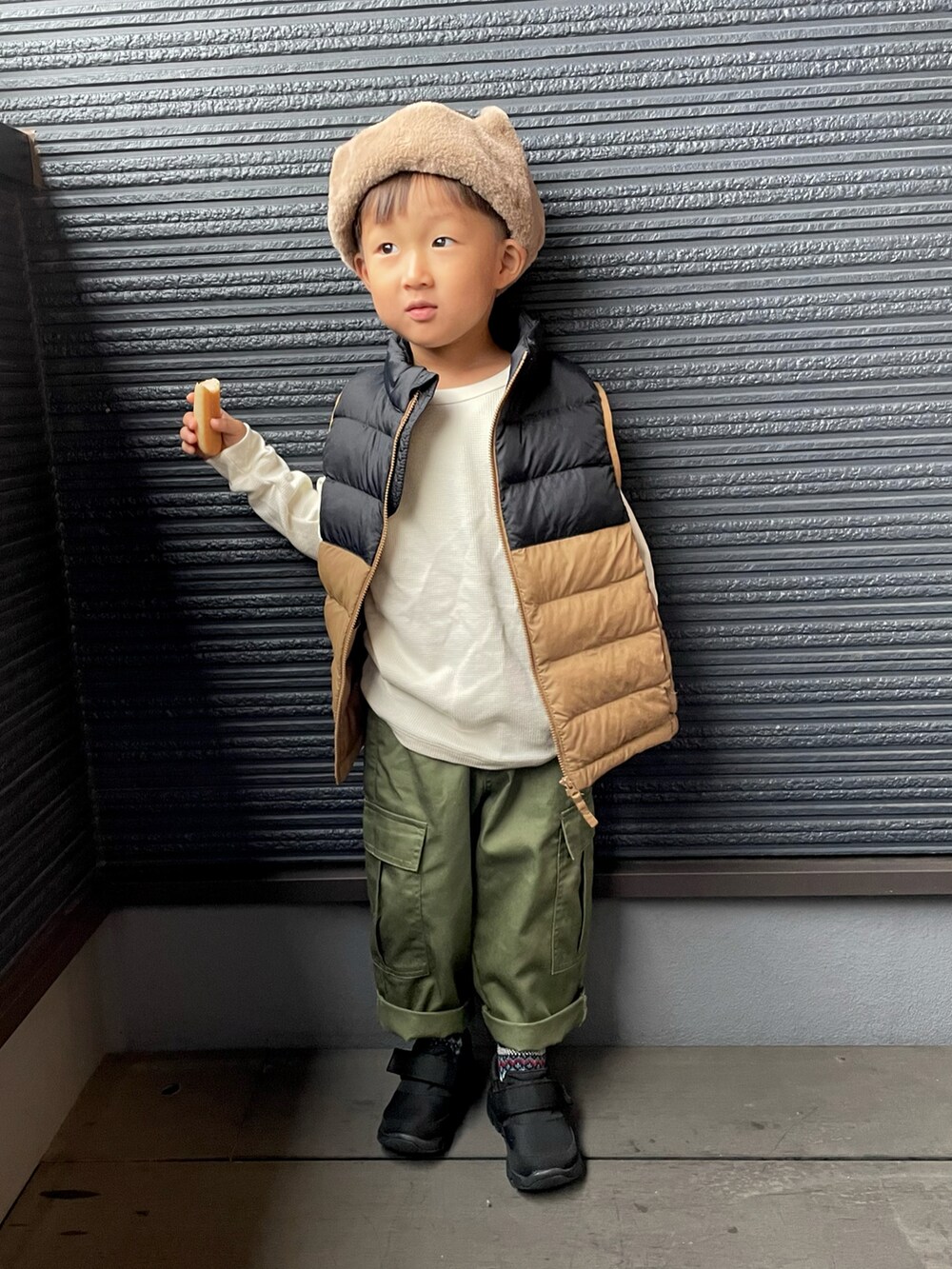 ブラウン系のダウンジャケット/コート、ブラック系のスニーカー、ブルー系のソックス/靴下を着用したキッズの秋コーディネートの3枚目の写真