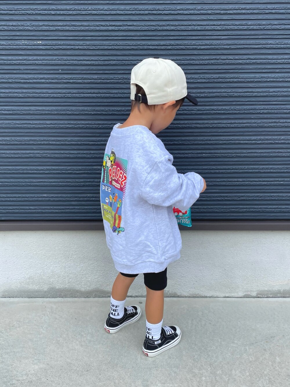 グレー系のスウェット、ブラック系のスニーカー、ブラック系のキャップを着用したキッズの秋コーディネートの2枚目の写真