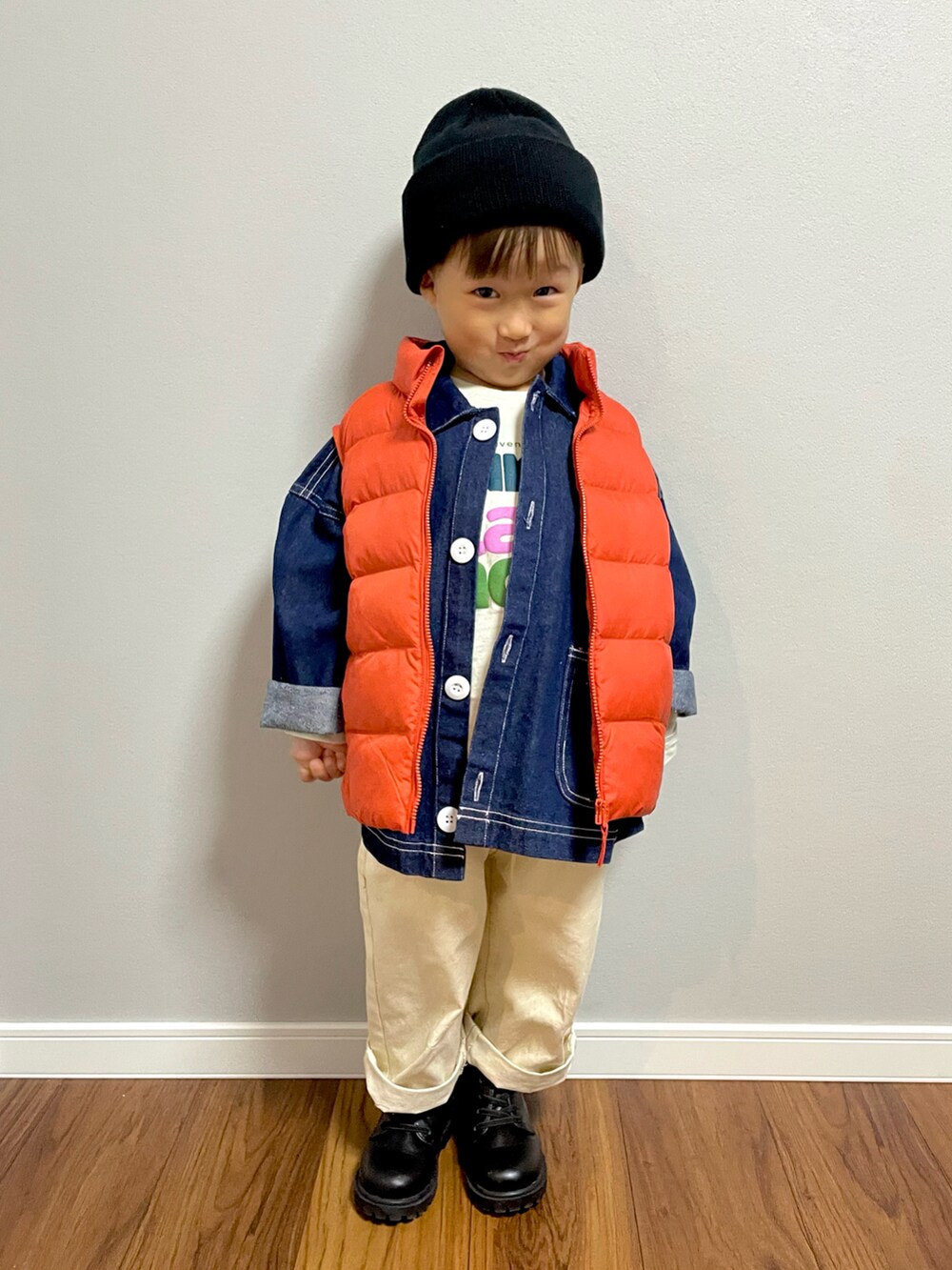 オレンジ系のダウンベスト、ブルー系のデニムジャケット、ホワイト系のデニムパンツを着用したキッズの秋コーディネートの4枚目の写真