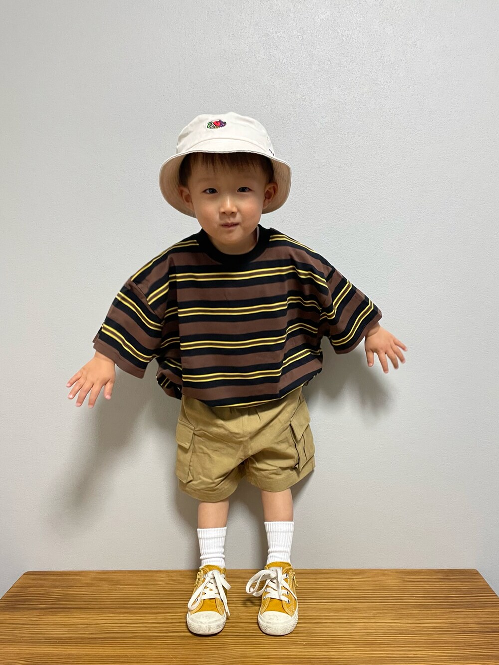 ブラウン系のTシャツ/カットソー、ベージュ系のその他パンツ、イエロー系のスニーカーを着用したキッズの春コーディネートの3枚目の写真