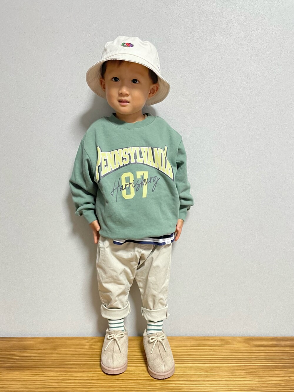 グリーン系のスウェット、ブルー系のTシャツ/カットソー、ホワイト系のパンツを着用したキッズの秋コーディネートの3枚目の写真