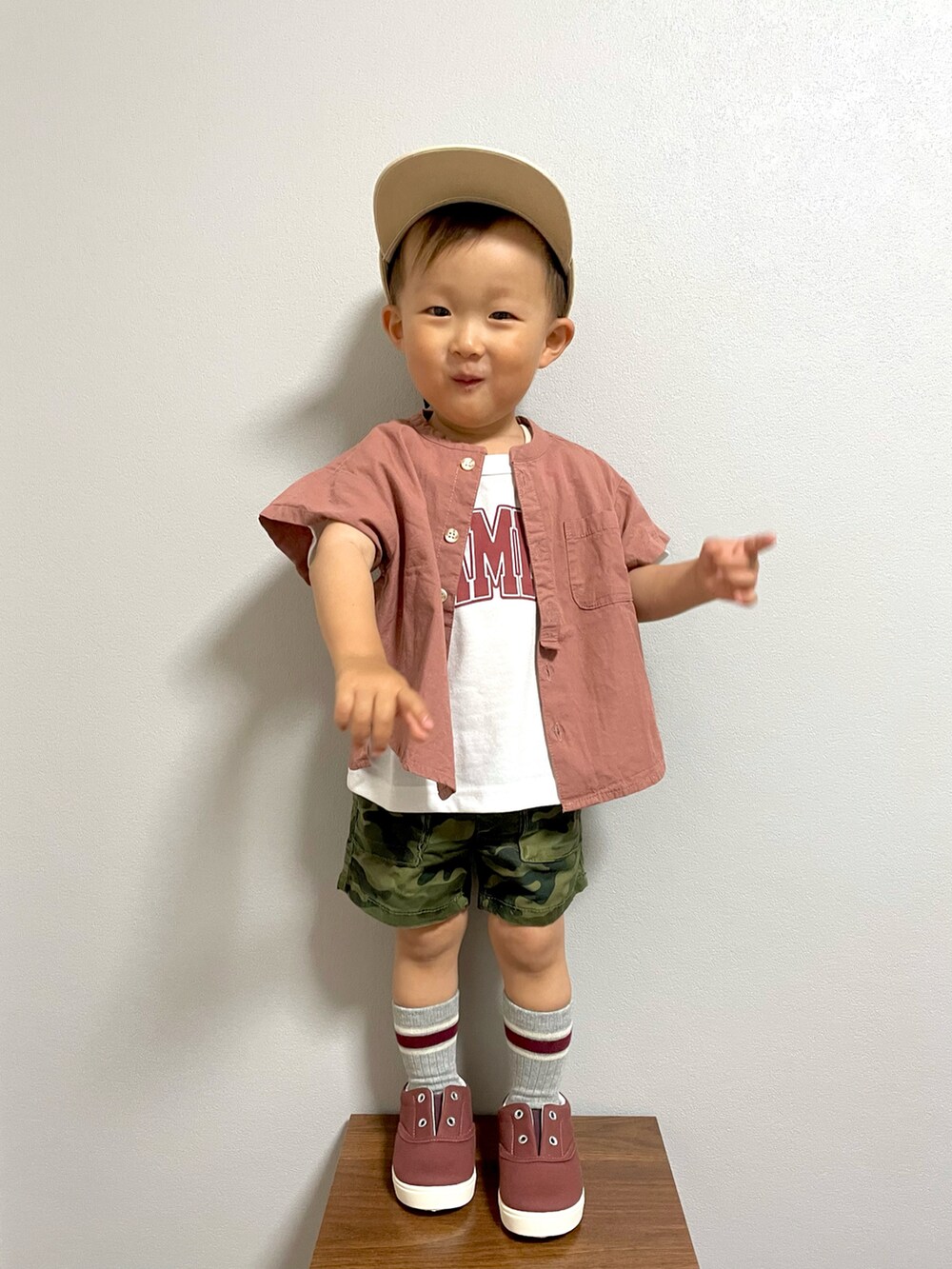 グリーン系のカーゴパンツ、レッド系のスニーカー、ベージュ系のキャップを着用したキッズの春コーディネートの2枚目の写真