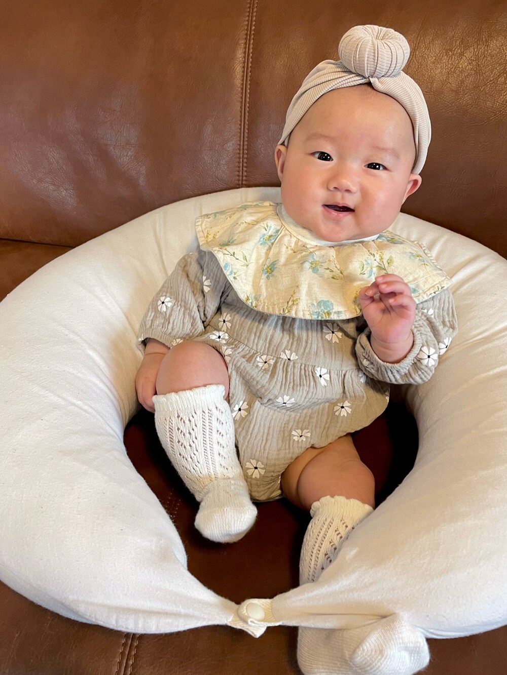 ベージュ系の帽子、グレー系のロンパース、ホワイト系のソックス/靴下を着用したキッズの秋コーディネートの3枚目の写真