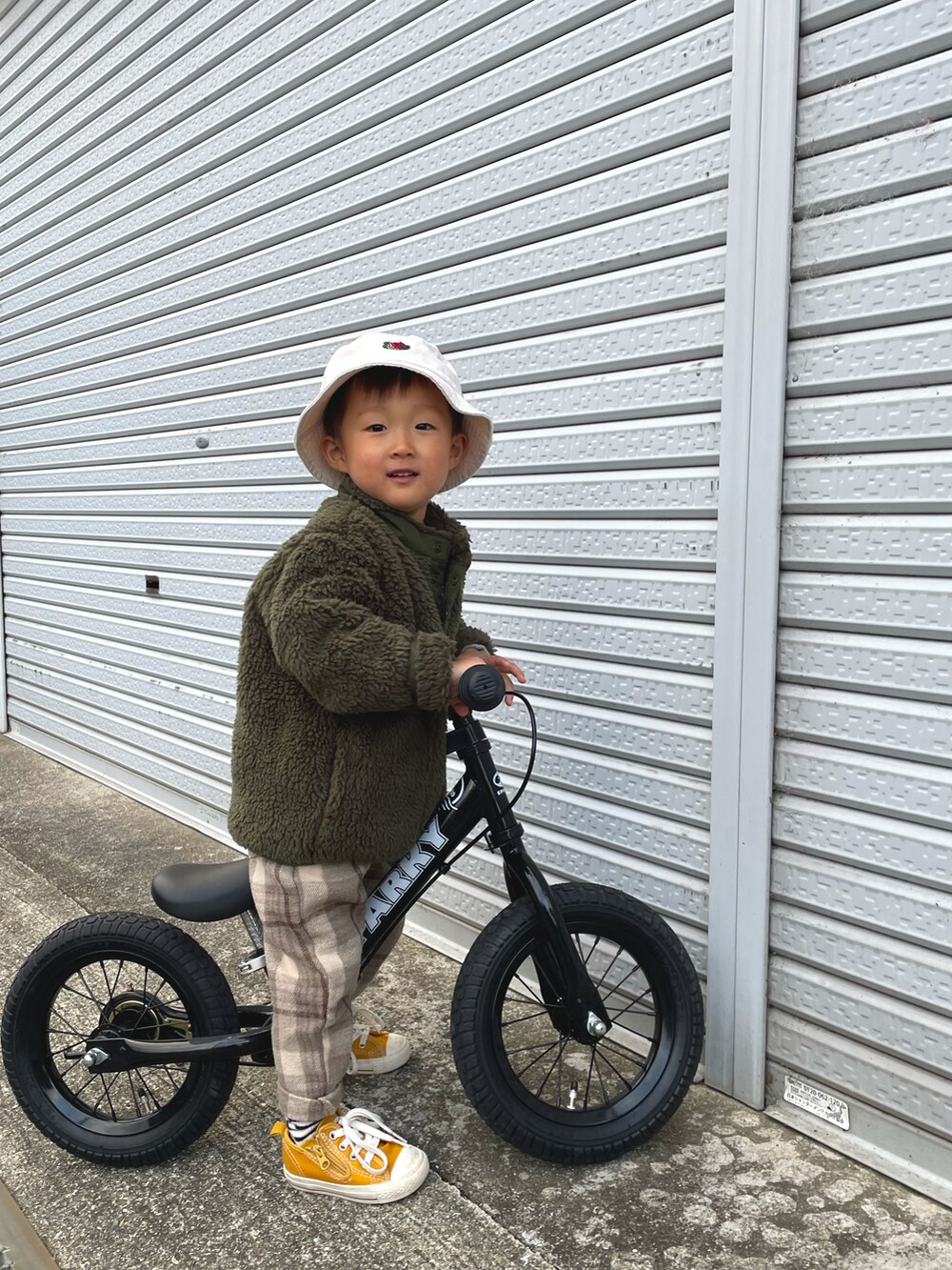 グリーン系のブルゾン、イエロー系のスニーカー、ベージュ系のその他パンツを着用したキッズの春コーディネートの4枚目の写真